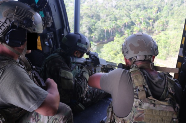 Operações Especiais - Uma serpente negra passa em frente de um atirador  camuflado durante treinamento de infantaria próximo à Base Aérea de Eglin,  na Flórida, Estados Unidos. Os snipers são treinados para